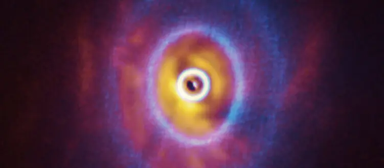 Triple star stirs up its own protoplanetary disk